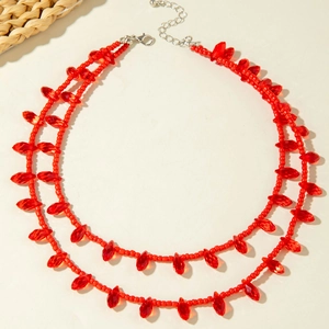Detail of bohemian double-layer necklace with red beaded chains and teardrop beads