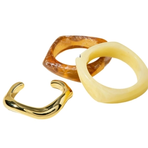 Irregular gold metal bangle with amber tortoiseshell and cream acrylic resin bracelets