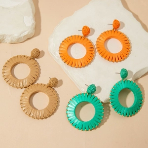 Three pairs of Bohemian raffia woven hoop earrings with gold bead trim in vibrant colors