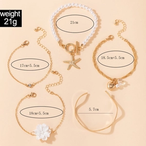 Detailed view of a 5-piece gold bracelet set with pearls, camellia and heart charms