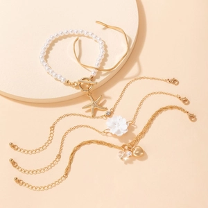 Multi-layer gold bracelet set featuring pearls, camellia flowers and starfish charms