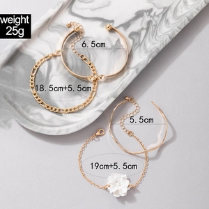 Detail of gold layered bracelets featuring a 3D camellia flower and OT toggle clasp