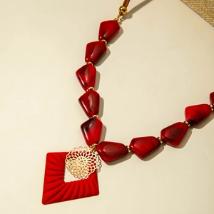 Long collier vintage avec perles en résine marbrée rouge et pendentif doré sur cordon