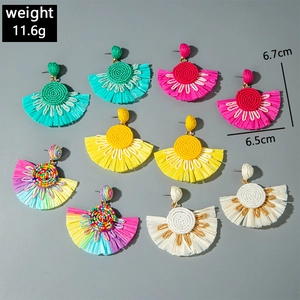 Detail view of colorful raffia fan-shaped earrings with bohemian beaded circular discs