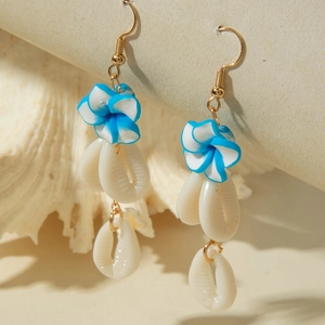 Macro detail of blue clay flower earrings with natural white shell charms on gold hooks
