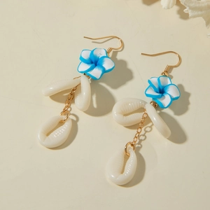 Detail of beach-style earrings featuring blue plumeria flowers and white shell charms
