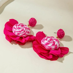 Detailed macro view of hot pink fabric flower earrings with woven spiral center design