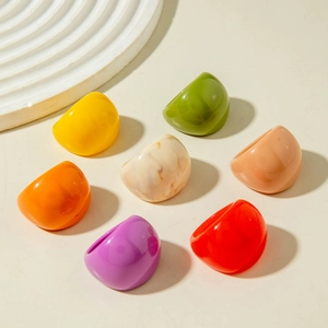 Set de anillos anchos de acrílico en siete colores vibrantes sobre soportes blancos puros