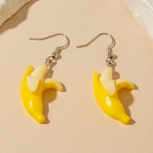 Creative mini banana earrings with peeled fruit design on minimalist background