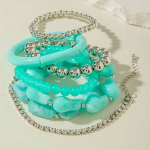 Détail de bracelets bohèmes superposables avec perles vert menthe et anneaux en argent