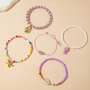 Detail view of 5-piece bohemian beaded anklet set with shells and starfish charms