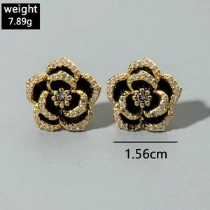 Close-up of black enamel flower earrings with white crystals showing 1.56cm diameter