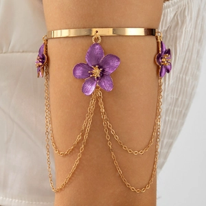 Detail of gold arm cuff with purple floral charms and elegant metal fringe tassels