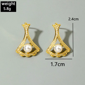 Close-up of fan-shaped pearl earrings with gold plating and sparkling zircon micro-pave
