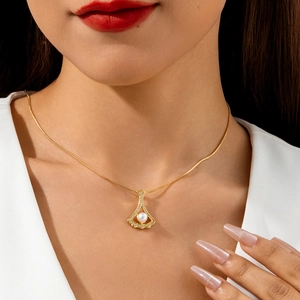 Elegant gold snake chain necklace with a diamond-set fan pendant and a white pearl