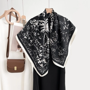 Elegant black and white floral printed square scarf with silky luster on a black dress