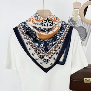 Navy and orange paisley square silk scarf styled on a white shirt with a wooden hanger