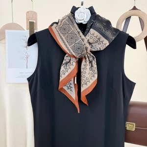 Retro geometric print silk scarf with camellia brooch on a black sleeveless top