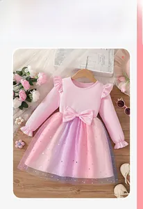 Detail of pink long sleeve dress with ruffled shoulders and starry rainbow tulle skirt