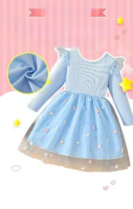 Détail de la robe bleu clair montrant le coton côtelé et la broderie de marguerites
