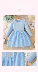 Détail de robe bleue pour fille avec broderie de marguerites et jupon en tulle souple