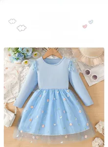 Détail de robe bleue pour fille avec broderie délicate de marguerites et de lune