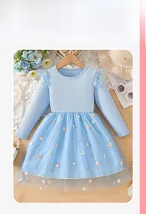 Détails d'une robe bleue pour fille avec broderies marguerites et jupe en tulle
