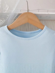Light blue rib-knit girls' dress with a round neckline on a wooden hanger display