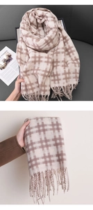 Detail of classic plaid scarf featuring thick knit fabric and dense fringe tassels