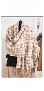 Detail of soft cashmere feel scarf showing brown plaid pattern and classic fringe tassels