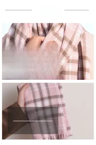 Close-up of soft plaid scarf featuring pink and brown grid pattern with fringe tassels