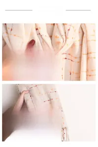 Detail showing the soft cashmere-like texture and orange plaid pattern with fringes