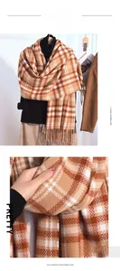 Macro detail of thick plaid cashmere scarf texture with soft orange and camel fringe