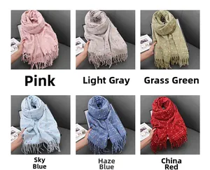 Close-up of cashmere-feel scarves with colorful plaid patterns and fringe details