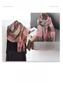 Detail of soft cashmere-like knit scarf with color-block plaid pattern and long fringe