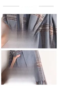 Detailed view of blue and brown checkered scarf fabric with soft fringe edge