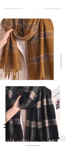 Macro detail of soft imitation cashmere fabric texture with fringe on plaid winter scarves