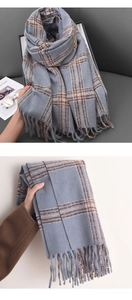 Detail of grey plaid scarf featuring brown stripes and long decorative fringes