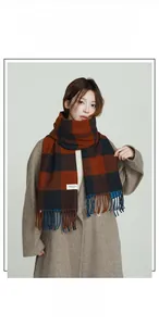 Detail of soft plaid scarf featuring orange and navy checks with elegant fringe trim