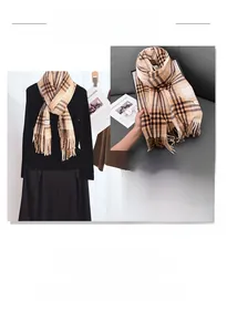 Detail of classic plaid scarf with fringe edge in beige brown and black wool blend