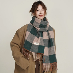 Plaid tassel scarf in green and pink checkerboard pattern on a stylish winter model