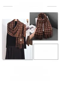 Detail of soft brown and black checkered scarf with thick tassels for winter warmth