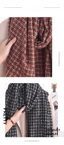 Détail d'une écharpe en imitation cachemire à carreaux avec pompons pour la mode d'hiver