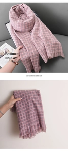 Détail d'une écharpe à carreaux en imitation cachemire avec franges et tons pastels