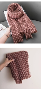 Vue détaillée d'une écharpe épaisse à carreaux rouge brun avec texture tricotée et franges