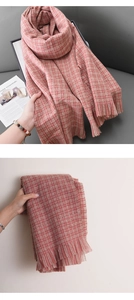 Gros plan d'une écharpe à carreaux rouge et beige montrant la texture épaisse