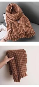 Détail d'une écharpe à pied-de-poule marron montrant la texture douce et les franges