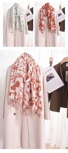 Détail d'une écharpe fleurie style cachemire avec franges sur un manteau en laine beige
