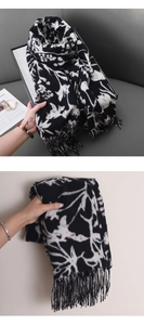 Détail d'une écharpe fleurie noir et blanc en imitation cachemire avec des franges