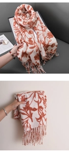 Détail d'une écharpe en cachemire synthétique à motifs floraux et pompons